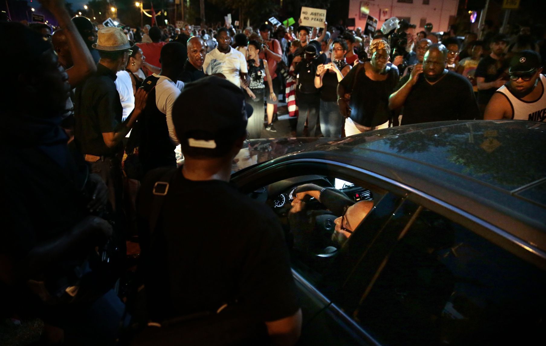 Protesters allow driver through march after seeing him armed